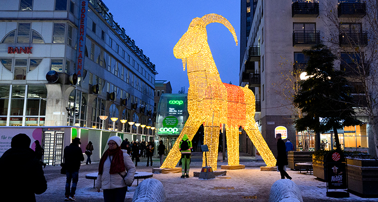 Medborgarplatsen i Stockholm. Där står en stor bock som är gjord av metall och lampor. Den lyser. Människor står och tittar på den.