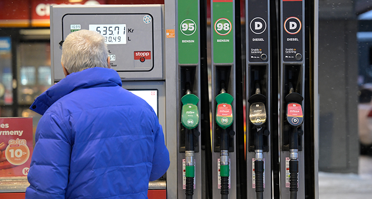 En man står vid pumpar på en mack.