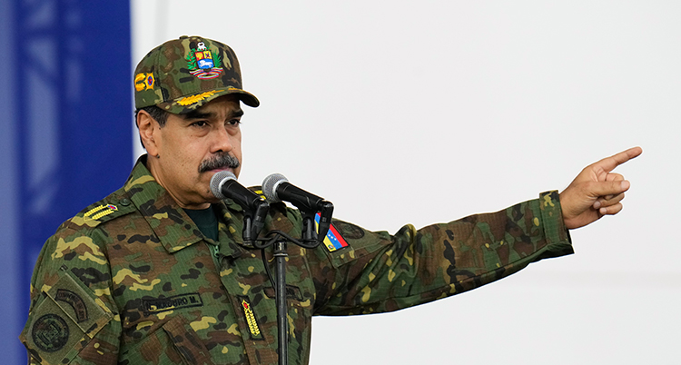 Han har en jacka som liknar militärernas. Han pekar med sin hand.