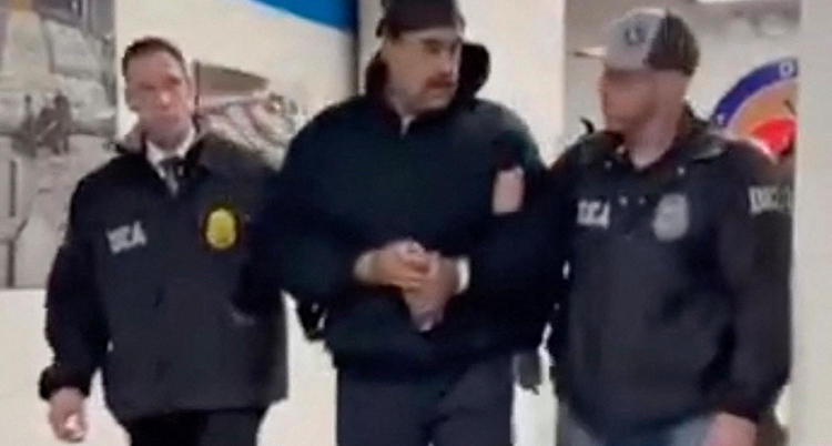 De går på varsin sida av Maduro. Maduro har mössa och svarta kläder.