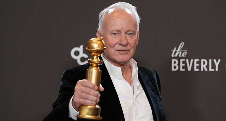 Han håller i ett pris i guld.
