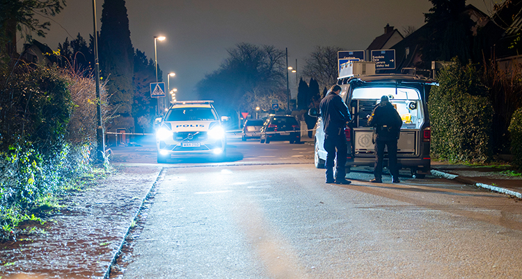Det är mörkt. Flera poliser och bilar är på en gata i Malmö.