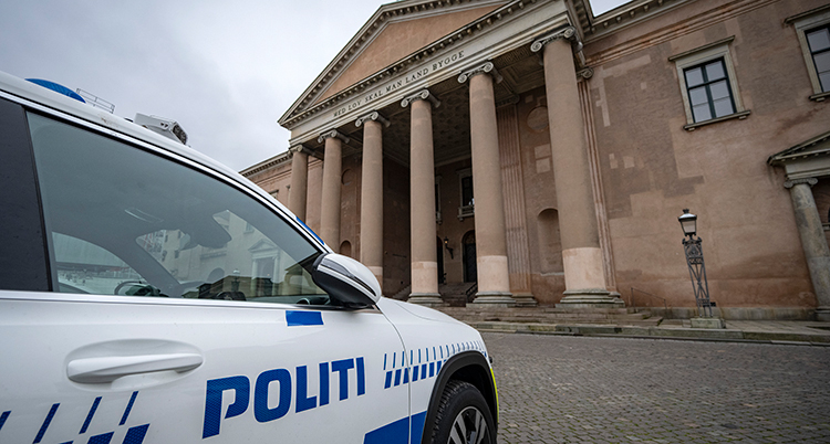 En polisbil framför ett stort hus.