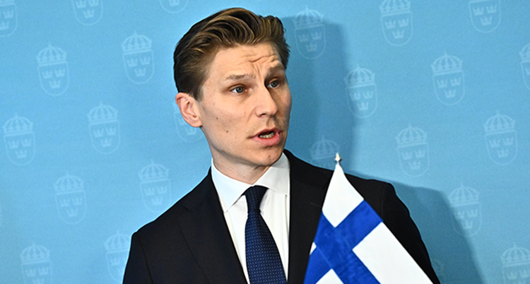 Han pratar. En finsk flagga syns.