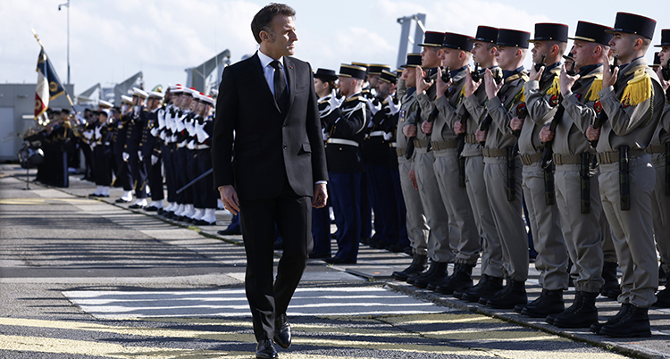 Macron går och tittar på uppställda franska soldater.