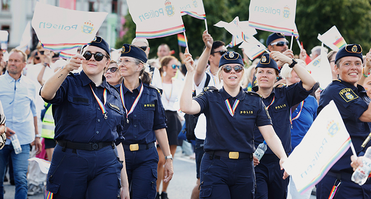 Poliser i poliskläder och med band i regnbågens färger runt halsen.