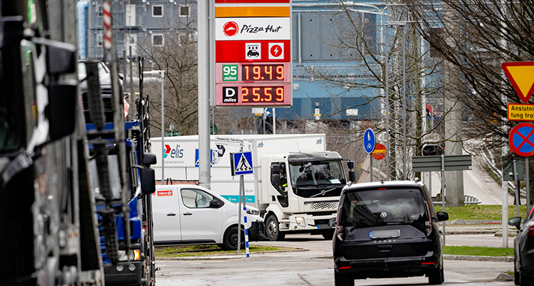 Flera bilar som står vid en mack som säljer bensin.