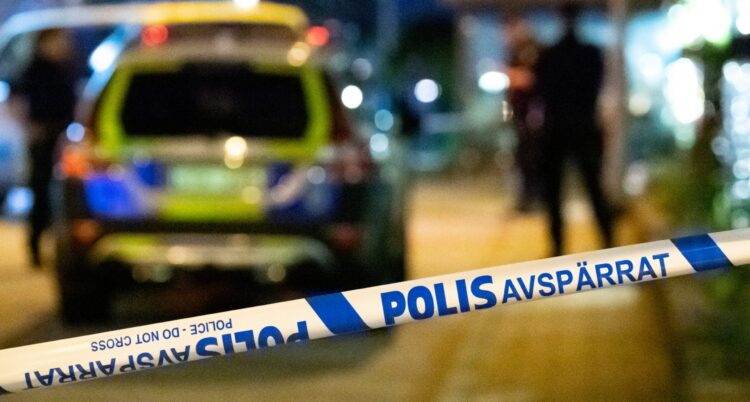 Polisbil och polisband på kvällen.