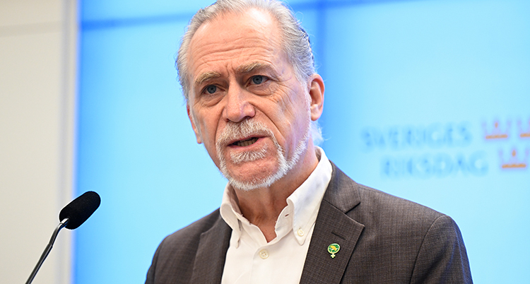 Han pratar i en mikrofon.