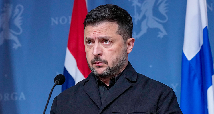 Bild på hans ansikte. Han är på ett möte med journalister.