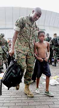 En amerikansk militär hjälper en pojke att lämna det översvämmade New Orleans. Foto: James Nielsen/Pressens Bild