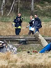 Poliser undersöker resterna av den störtade helikoptern. Foto: Björn Larsson Rosvall