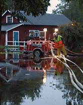 Claes Kämpe i Aneby jobbar med att få undan regnvatten vid en villa. Foto: Johan Nilsson/Scanpix