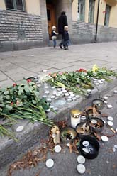 Blommor och ljus på trottoaren i Stockholm där en 16-årig pojke blev misshandlad till döds. Foto: Fredrik Sandberg/Scanpix