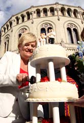 Den norska finansministern Kristin Halvorsen gillar beslutet om samkönade äktenskap. Hon firade genom att äta bröllopstårta utanför stortingets hus i Oslo. Foto: Cornelius Poppe/Scanpix