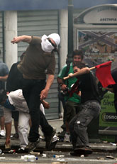 Demonstranter kastar sten på poliserna. Foto: Alkis Konstantinidis/Scanpix