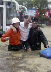 En man räddas från en översvämmad flod i Kina. Foto: AP/Scanpix