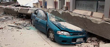 En bil har krossats av en bjälke från ett hus. Jordbävningen i Christchurch dödade minst 65 människor. Foto: Mark Mitchell/Scanpix