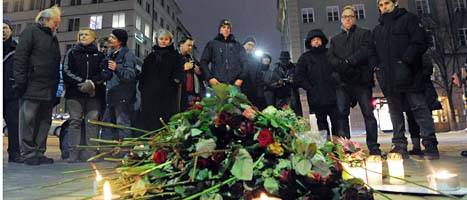 Blommor och ljus vid mordplatsen på Sveavägen i Stockholm. 
Foto: Janerik Henriksson/Scanpix