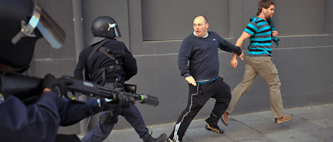 Demonstranter i staden pamplona flyr undan poliserna. Foto: Francois Mori/Scanpix.