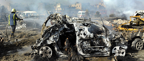 En brandman släcker brinnande bilar efter torsdagens sprängning i Damaskus. FOTO: AP Photo/SCANPIX