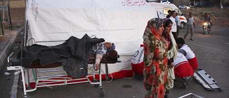 En kvinna ligger skadad på en bår i staden Varzaqan. Minst 300 har dött efter jordbävningar i nordvästra Iran. FOTO: Hamed Nazari/SCANPIX