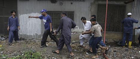 Räddningsarbetare utanför fabriken i Karachi. Foto: Fareed Khan/AP/Scanpix