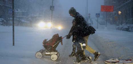 En man med barnvagn i snövädret i Stockholm. Foto: Bertil Enevåg/Scanpix.