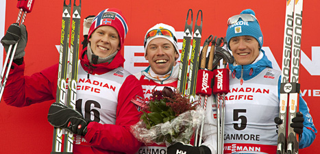 Emil Jönsson i mitten firar en ny seger i världscupen. Till vänster är tvåan Anders Glöersen från Norge och till höger Nikita Kriukov från Ryssland. Foto: Jeff McIntosh/Scanpix
