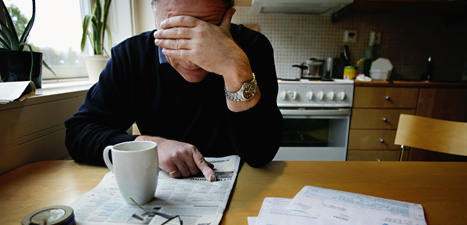 En arbetslös man dricker kaffe och läser annonser om jobb. Foto:Jessica Gow/Scanpix.