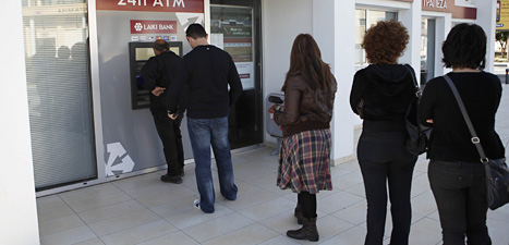 Folk på Cypern köar för att ta ut  pengar från banken. Foto: Petros Karadjias/Scanpix.