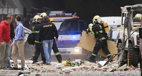 Poliser och räddningsarbetare vid huset där olyckan hände. 
Foto: David Josek/Scanpix.