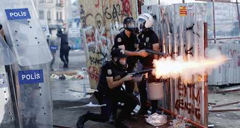 Poliser skjuter iväg tårgas mot demonstranterna. Foto: Kostas Tsironis/Scanpix.