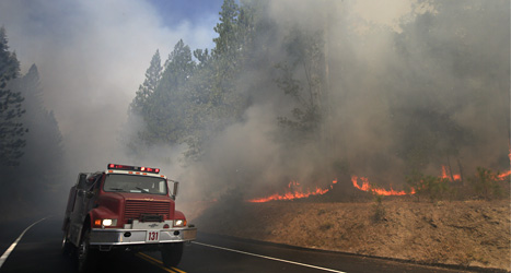 En brandbil kör förbi brinnande träd nära nationalparken Yosemite i USA. Foto: Jae C. Hong/AP/Scanpix.