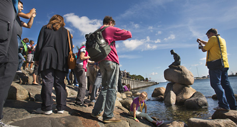 På en sten ute i vattnet sitter den lilla sjöjungfrun. Foto: Drago Prvulovic /Scanpix