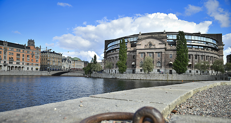 Ett stort hus i sten med vatten framför.