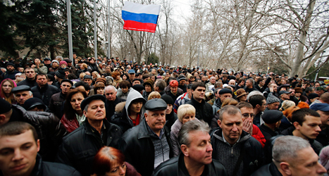 Människor i staden Sevastopol i området Krim protesterar mot förändringarna i Ukraina. De vill att Ukraina hellre ska bli en del av Ryssland. De har med sig en rysk flagga. Foto: Darko Vojinovic /AP /TT