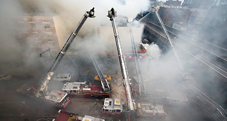 Brandmän försöker släcka elden i husen som exploderat.
Foto: John Minchillo/TT.