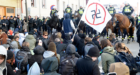 Folk har satt sig på en gata i Jönköping för att stoppa nazisterna. Foto: Mikael Fritzon /TT