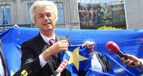 Geert Wilders har klippt sönder flaggan för att visa att han inte gillar EU. Han är ledare för ett högerextremt parti i Nederländerna. Foto: AP/TT