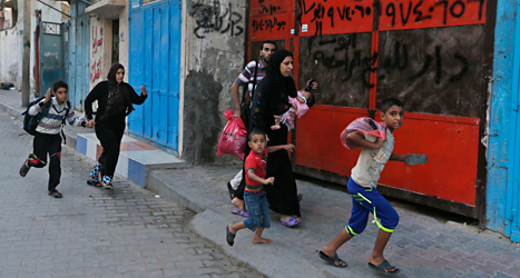 Palestinier springer till ett skyddsrum när Israels bombplan 
är på väg mot Gaza. Foto: Lefteris Pitarakis/TT.