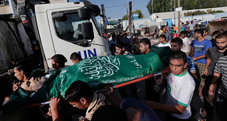 Männen bär på en person som dog i den senaste attacken mot en skola i Gaza. Foto: Lefteris Pitarakis/TT
