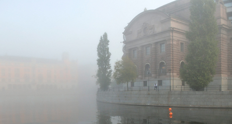 Riksdagshuset i dimma. Här kommer politikerna att rösta om flera viktiga frågor i höst. Foto: TT