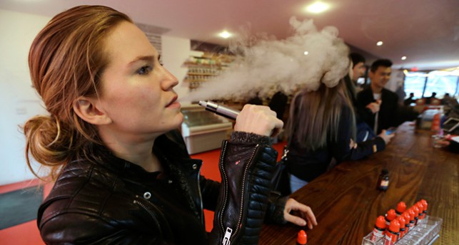 Kvinna som röker en e-cigarett