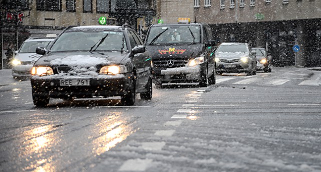 Snöiga bilar på en gata