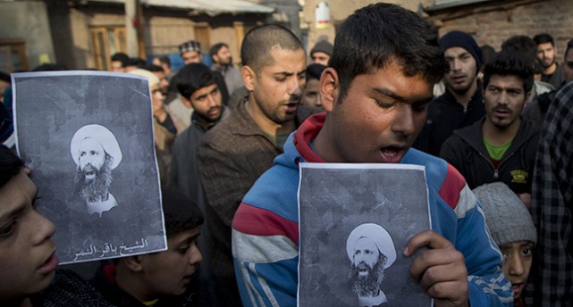Shiamuslimer håller upp bilder på den avrättade Nimr al-Nimr.