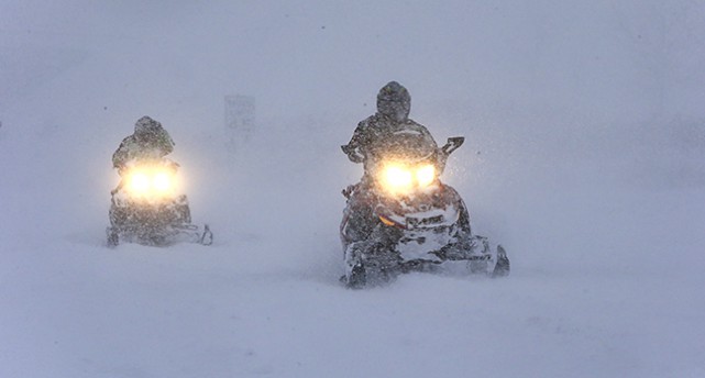 En snöskoter i snöstorm.