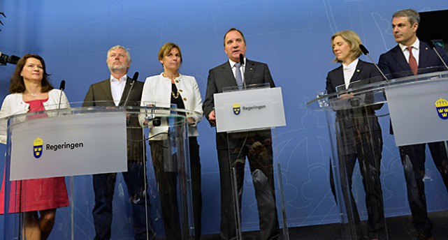 Ann Linde, Peter Eriksson, Isabella Lövin, Stefan Löfven, Karolina Skog och Ibrahim Baylan står vid ett podium.