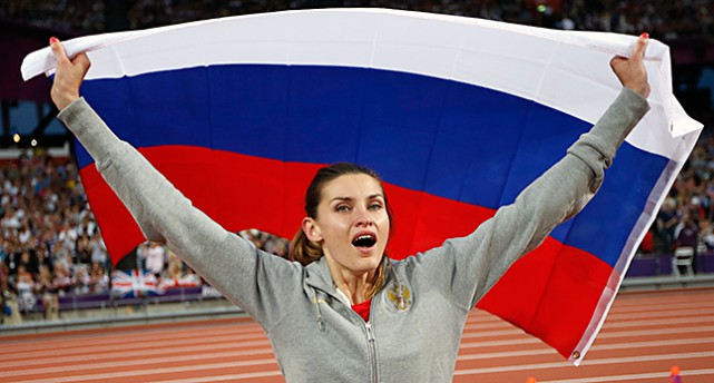 Höjdhopparen Anna Tjitjerova håller en rysk flagga.
