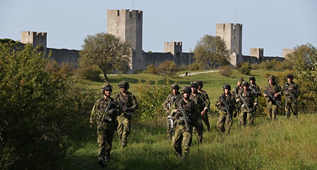 Soldater går bredvid muren i Visby.